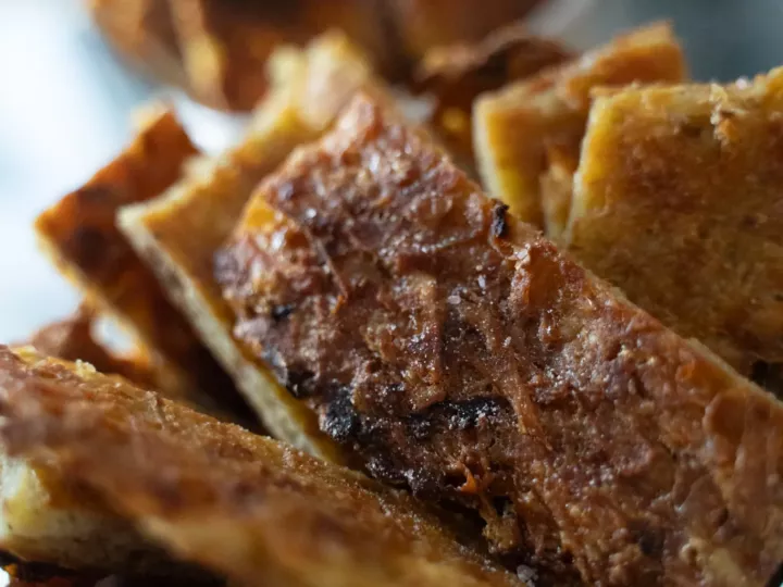 Crousti-galette de pommes de terre dorée, servie en morceaux dans un ramequin blanc