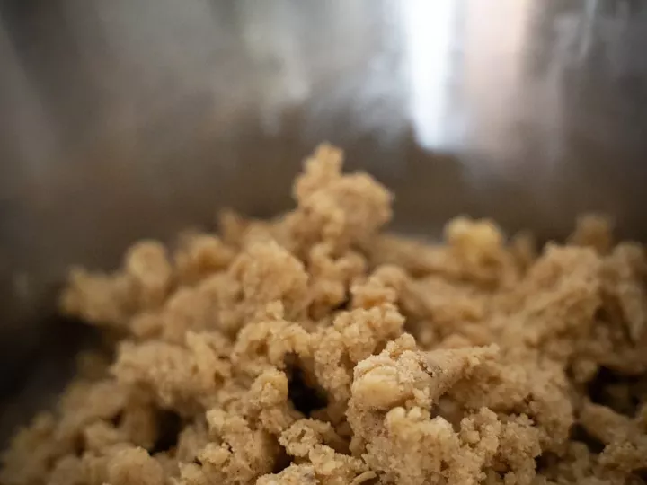 Pâte à crumble sableuse en gros morceaux dans un saladier en inox