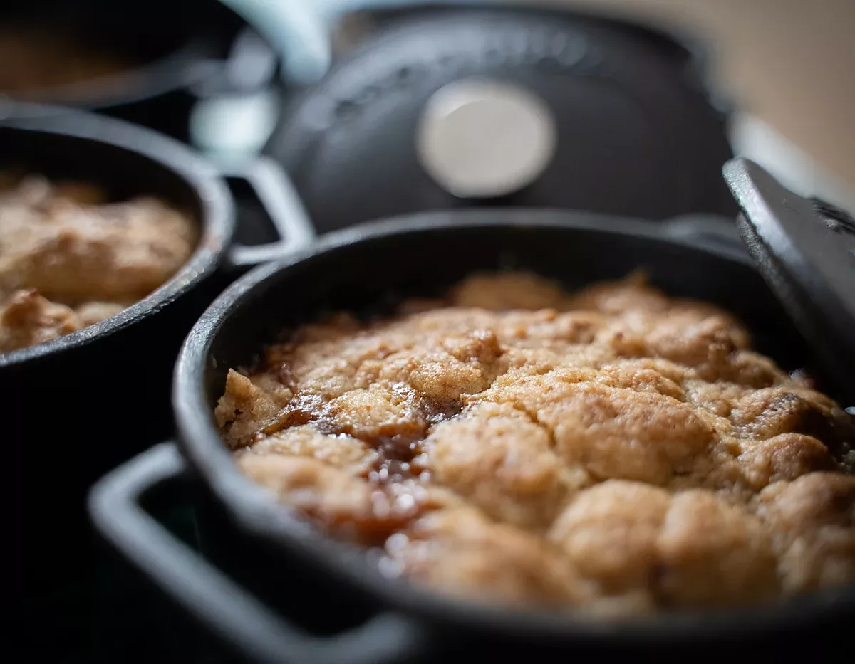 Petit crumble pomme-poire doré dans sa mini-cocotte en fonte, avec le jus caramélisé qui déborde