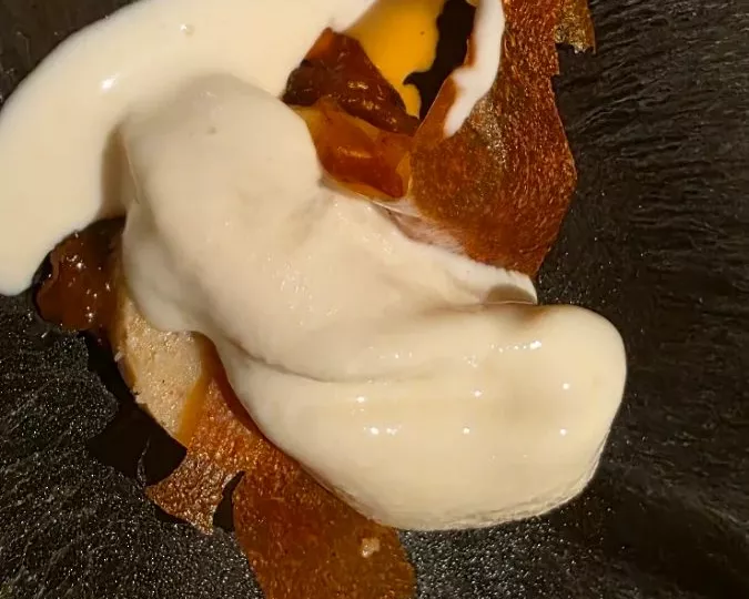 Crème et tuile croustillante dans une assiette sombre, restaurant Étude à Aix-en-Provence