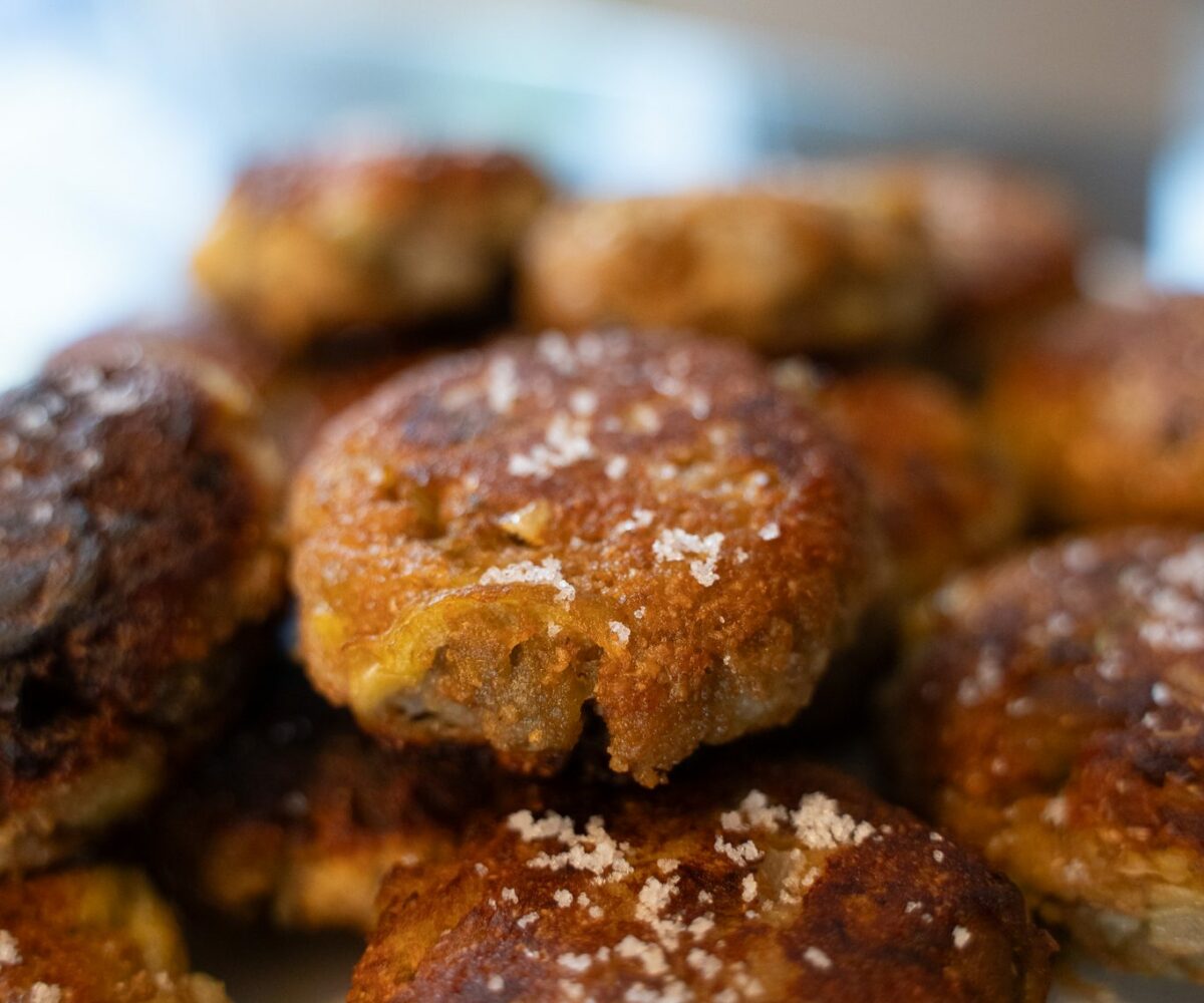 Polpette d'aubergine dorées et saupoudrées de fleur de sel, empilées dans une assiette