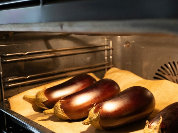 Aubergines entières sur une plaque au four avant la cuisson, pour les polpette d'aubergine