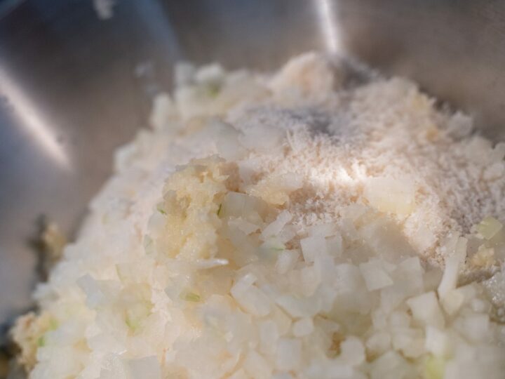 Saladier avec chapelure, parmesan, oignon émincé, ail râpé et œuf pour les polpette d'aubergine