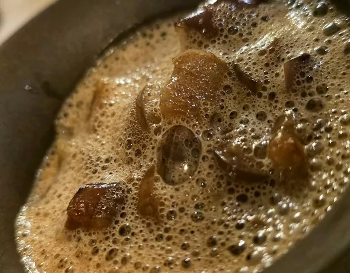 Bouillon mousseux servi dans un bol sombre, L'Horizon (visite 2025)