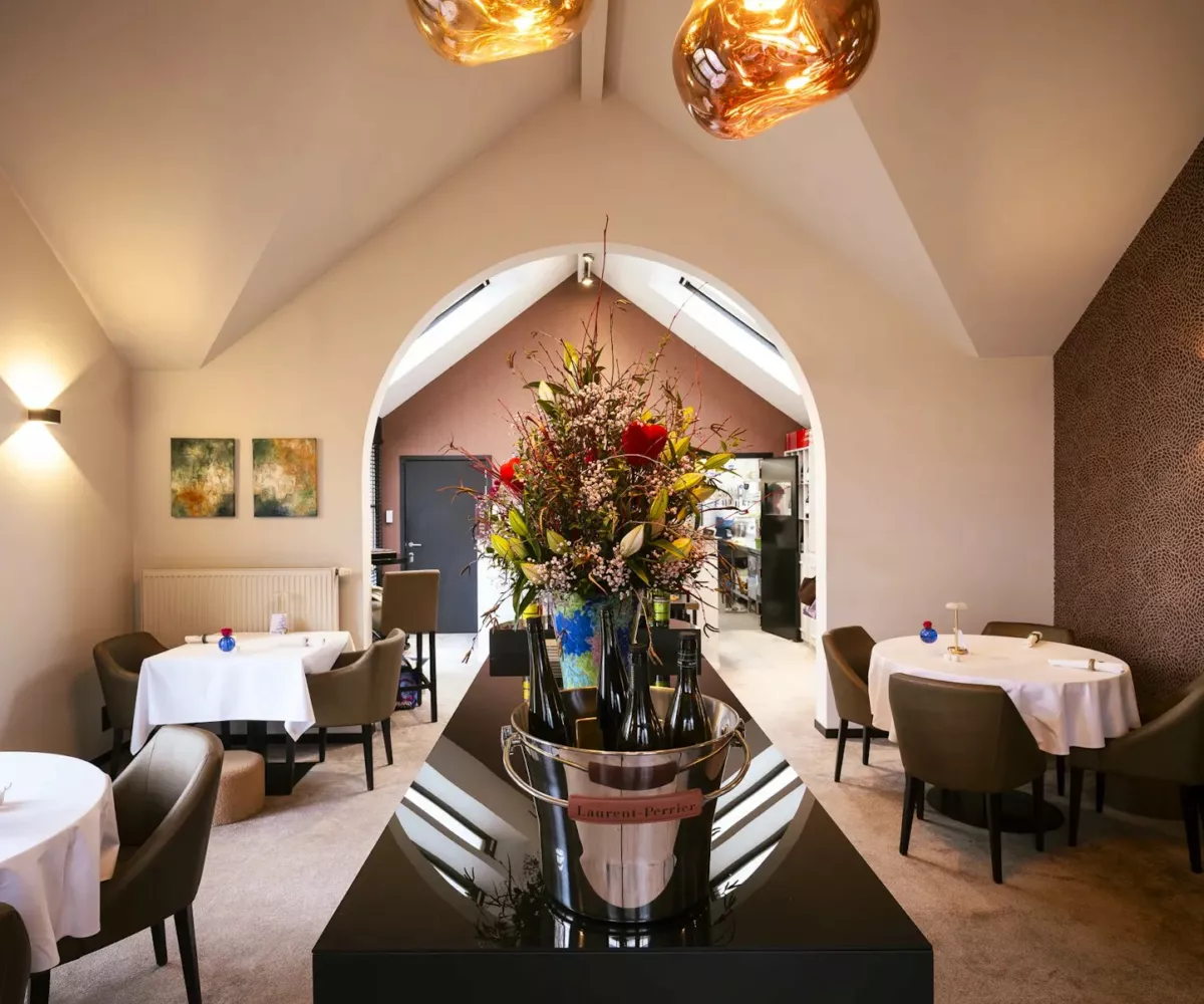 La salle du restaurant L'Horizon à Chaumont-Gistoux, avec son grand bouquet de fleurs et ses suspensions dorées