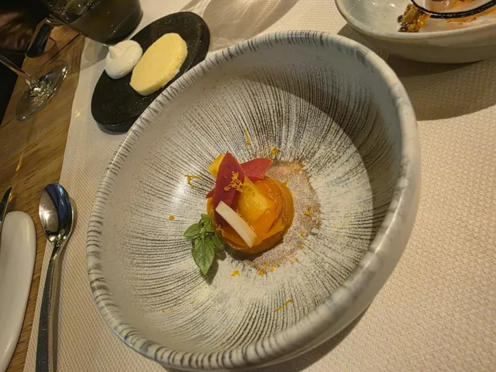 Dessert à la figue dans un bol rayé, avec la panna cotta sur une ardoise noire, chez Luma