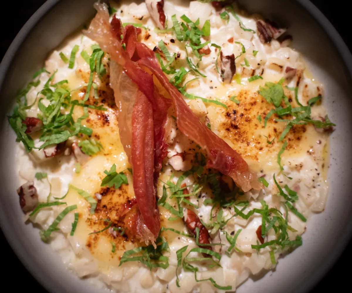 Risotto de céleri rave vu du dessus, comté gratiné, chips de serrano, noix de pécan et livèche
