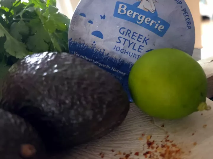 Avocats, citron vert, botte de coriandre, piment et pot de yaourt grec au lait de brebis pour la sauce verte